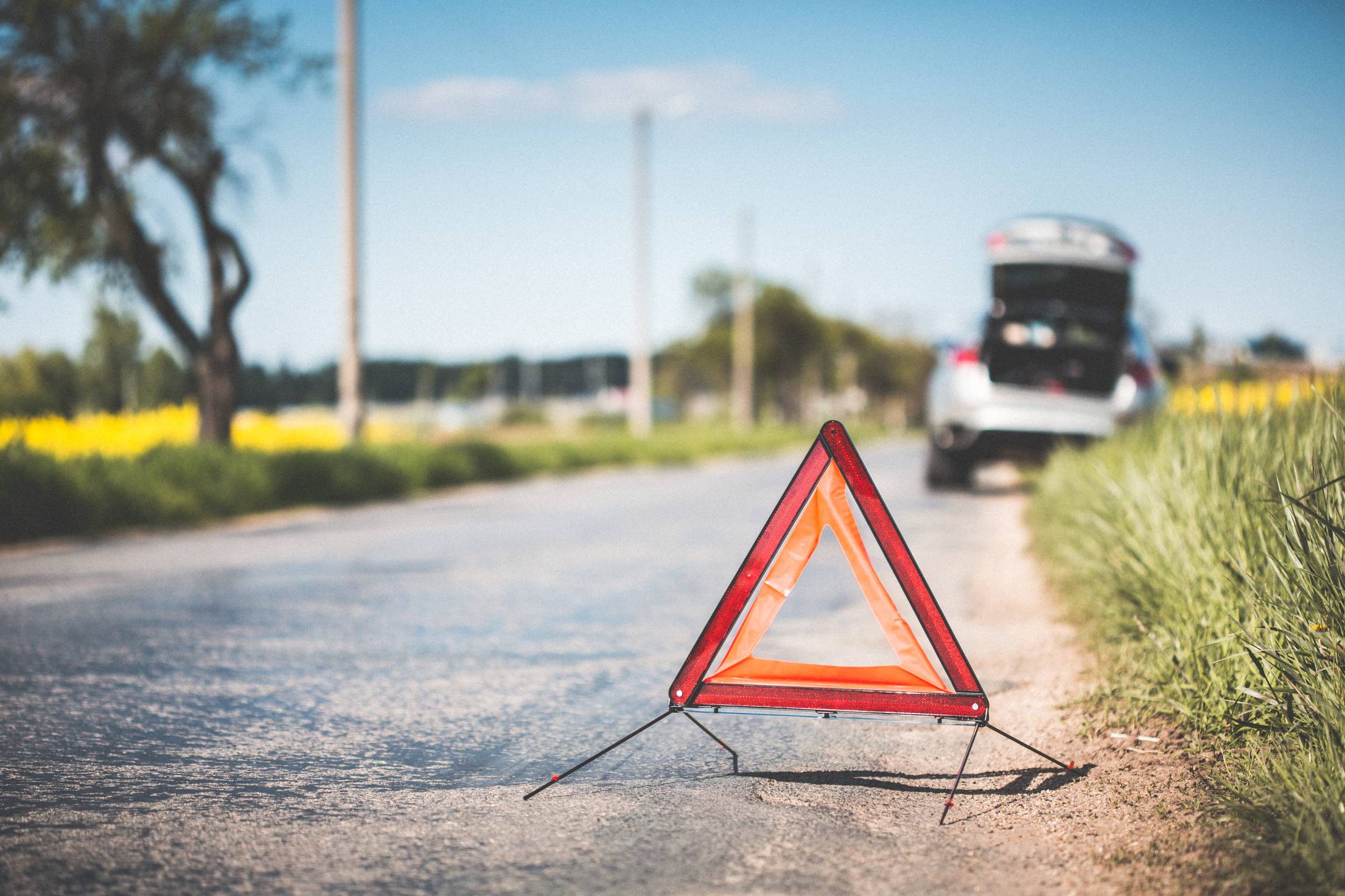 red-warning-triangle-and-broken-car-on-the-road.jpg